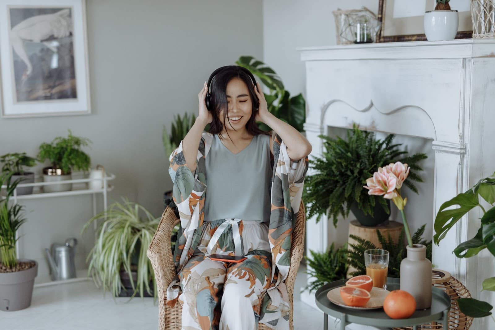 woman listening to music in a room full of houseplants